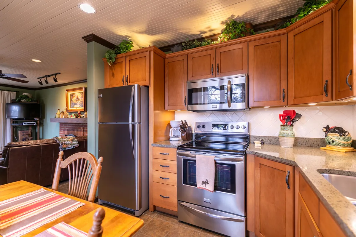 A cozy kitchen and dining space, with kitchen appliances, a well-set dining table, and decorative plants. The view highlights the practical layout and the intimate ambiance, suggesting a space perfect for both everyday meals and special occasions.